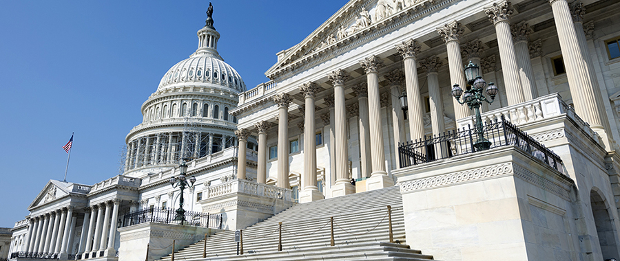 United States Capitol Building under construction against a beautiful blue sky