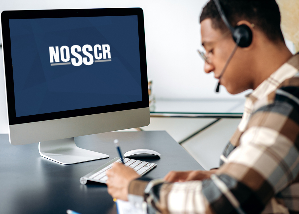 A young man on a headset taking notes on a NOSSCR webinar.